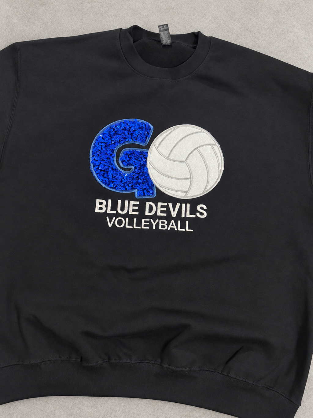 Clean product photo of black Volleyball Mom sweatshirt with blue sequin G and Blue Devils Volleyball design
